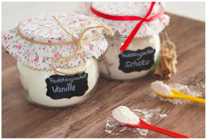 Zwei Gläser mit selbstgemachtem Vanillepuddingpulver und Schokopulver, liebevoll verziert. Perfekt zum vanillepuddingpulver selber machen.